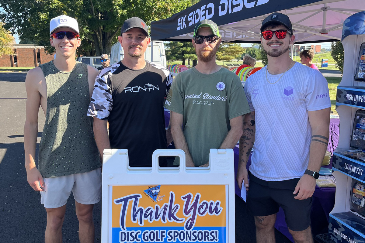 Winners of the tournament stand for a photo by the sponsorship sign.