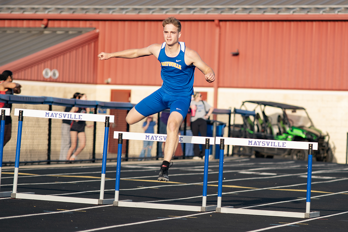 Maysville Senior Colin Mathers jumping the hurdles in a Tri-Meet on their home track