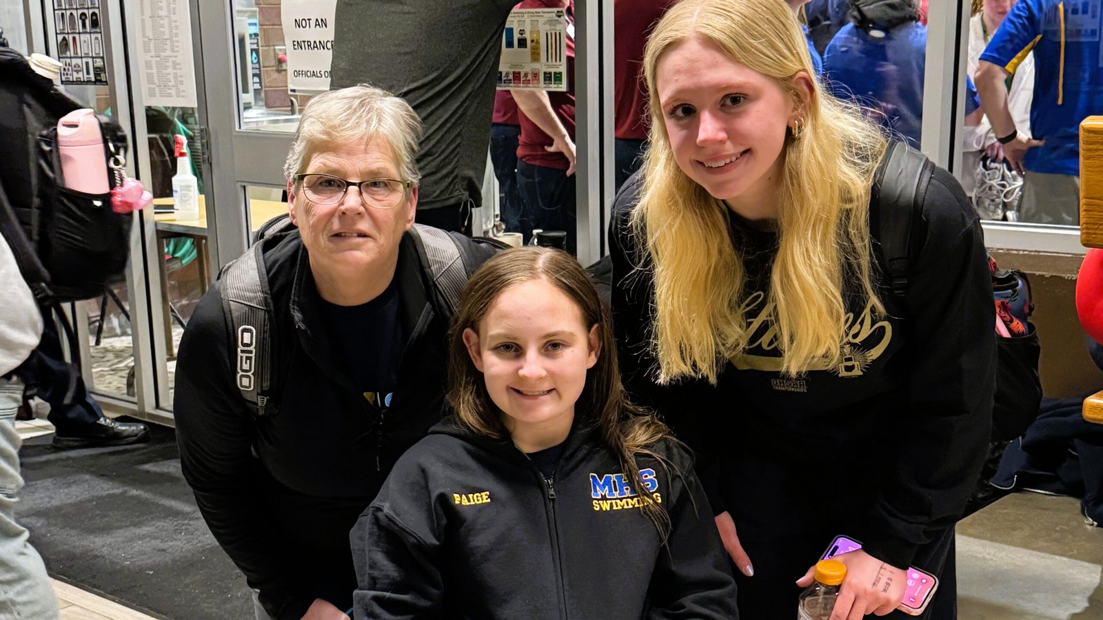Maysville’s Head Swim Coach, Theresa Baughman, freshman Paige Calendine, and junior Leila Hawk at State swim meet.