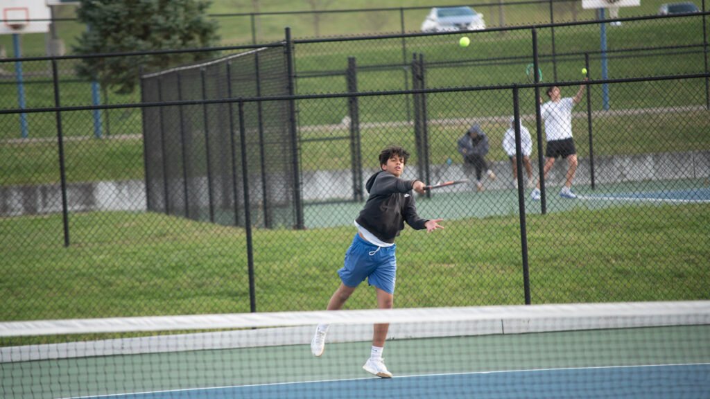 Zanesville's Subh Patel returns the ball in a tennis match against Cambridge