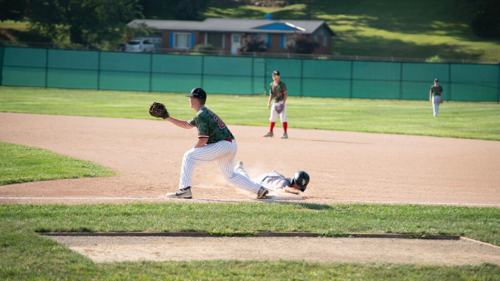 Cambridge's Greyson Forshey tries to tag a Zanesville runner trying to slide back to first base.